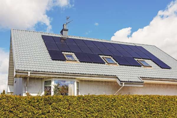 An array of residential solar panels on a suburban roof in this image from Shutterstock.