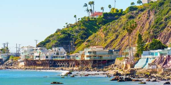 Waterfront homes tucked within the mountainside overlooking the ocean in this image from Shutterstock