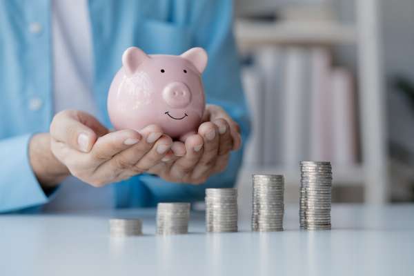 A pile of coins and a piggy bank in this image from Shutterstock